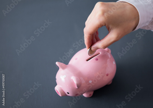 woman holding coin with piggy bank