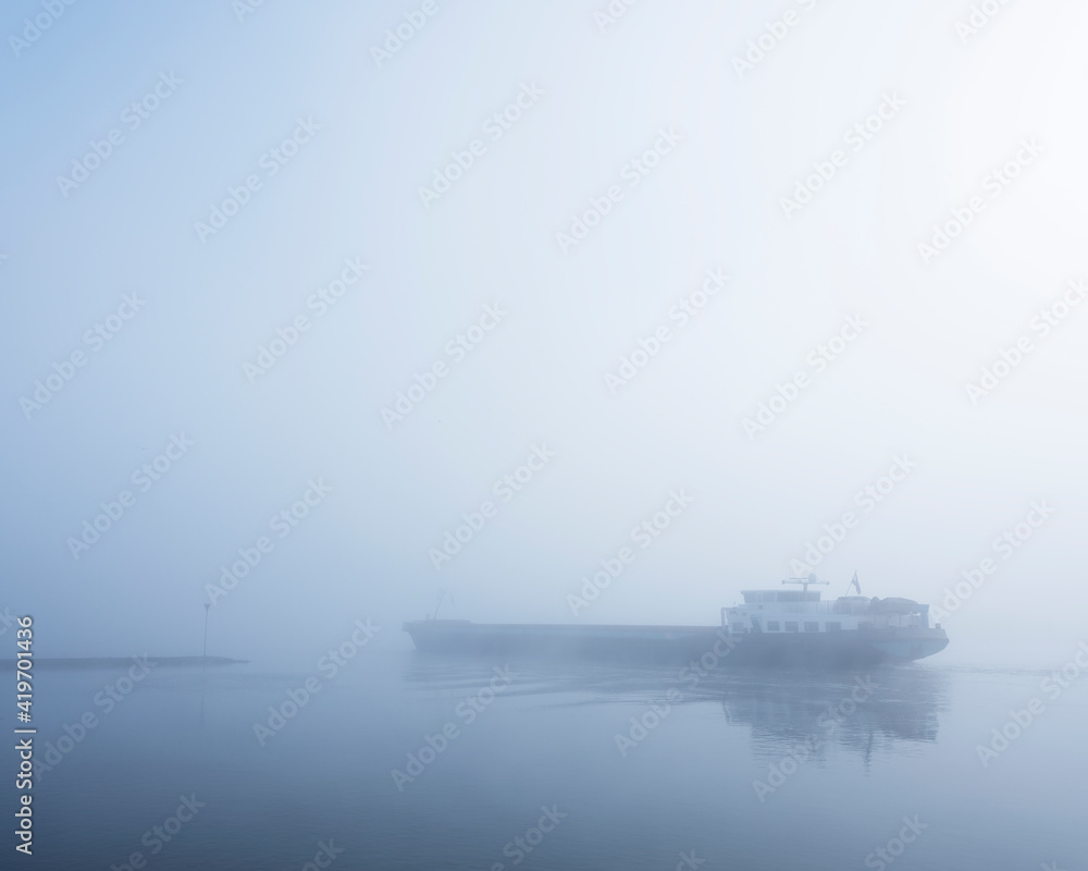barge in the mist on river rhine near utrecht in holland barge in the mist on river rhine near utrecht in holland