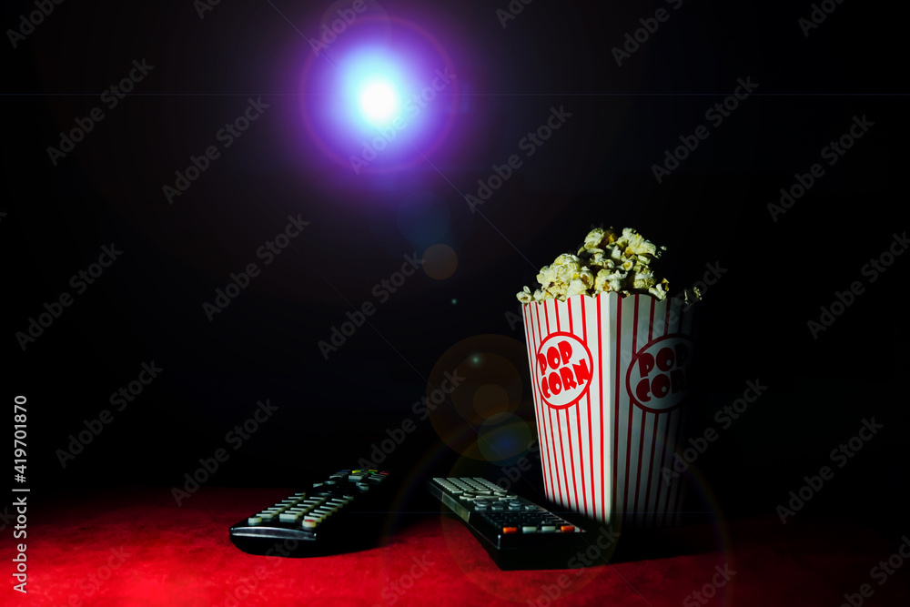 Popcorn in a red striped paper cup in the home theater room showing a ...