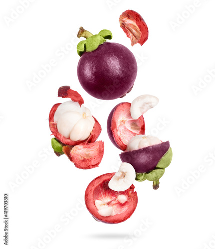 Photos Whole and sliced ripe mangosteen in the air, isolated on a white background