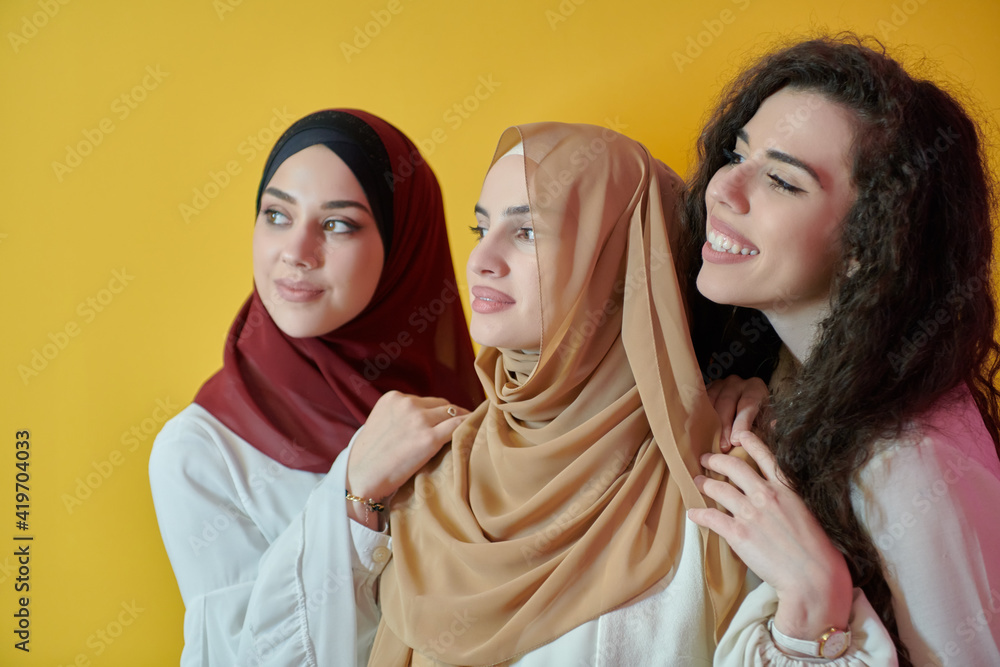 Young muslim women posing on yellow background Young muslim women posing on yellow background