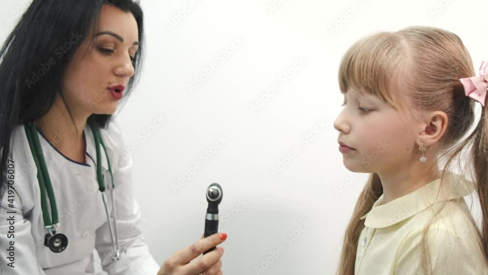 Little girl having a check up at pediatrician. The doctor is pulping and checking child's breathing, hearing and throat. Little girl having a check up at pediatrician. The doctor is pulping and checking child's breathing, hearing and throat.