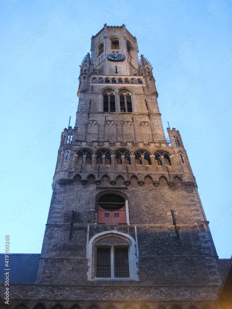 bell tower of the cathedral. Gothic cathedral country. Evening city view of the Belgian medieval old town. Scenic landscape with beautiful ancient brick building on a cold spring day.