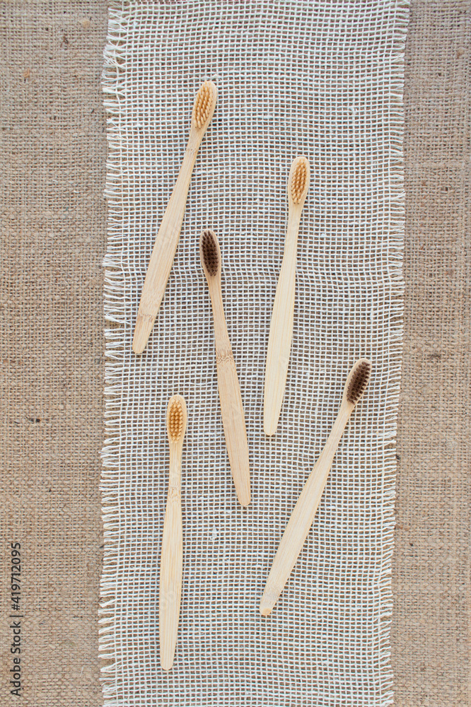 Mockup vertical image, set of natural bamboo toothbrushes on rustic background with copy space. Sustainable lifestyle, bathroom essentials in zero waste home. Dental health concept, selective focus Mockup vertical image, set of natural bamboo toothbrushes on rustic background with copy space. Sustainable lifestyle, bathroom essentials in zero waste home. Dental health concept, selective focus