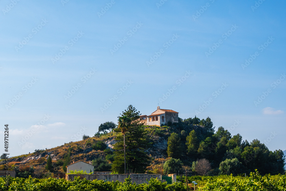 Small church of San Miquel, on a small hill surrounded by orange groves and country houses, in La Font d'En Carròs (Valencia, Spain)