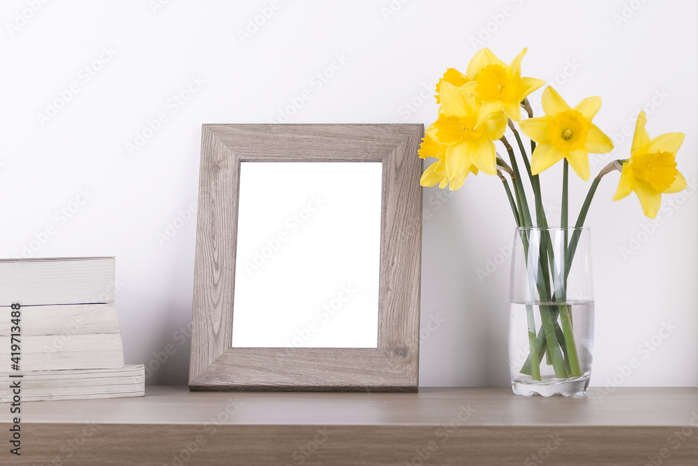 Breakfast still life., empty picture frame mockup on wooden desk, table. Vase with daffodils branches. Elegant working space, home office concept. Scandinavian interior design Breakfast still life., empty picture frame mockup on wooden desk, table. Vase with daffodils branches. Elegant working space, home office concept. Scandinavian interior design