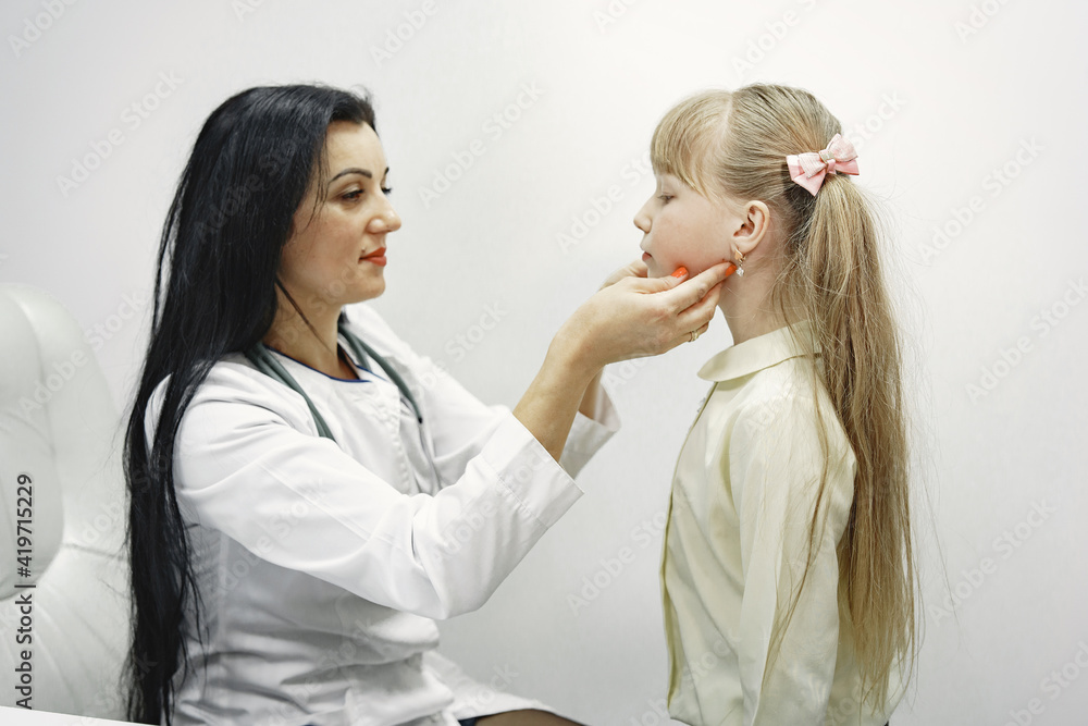 Girl with long hair. Doctor looks in ear. Hospital ward. Girl with long hair. Doctor looks in ear. Hospital ward.