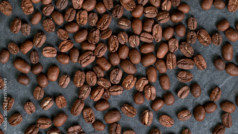 Falling Roasted Coffee Beans on Black Stone Background, close-up. Falling Roasted Coffee Beans on Black Stone Background, close-up.