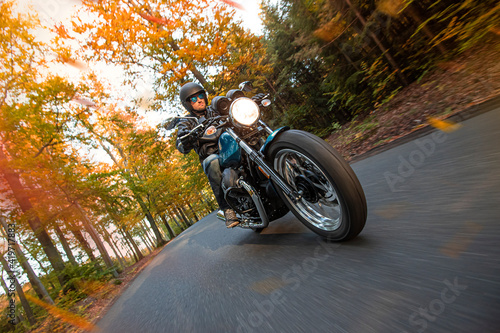 Moto racer riding on forest road during sunset, blurred motion. © Lukas Gojda
