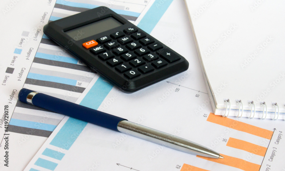 Profit bar chart, pen, notepad and calculator Profit bar chart, pen, notepad and calculator