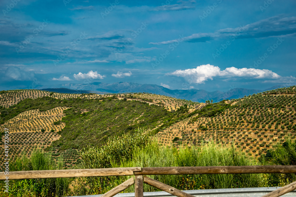 Mirador con su valla de madera en dirección a unas montañas con vegetación natural y reboblada y con nubes de lluvia en la comarca de Las Hurdes, España