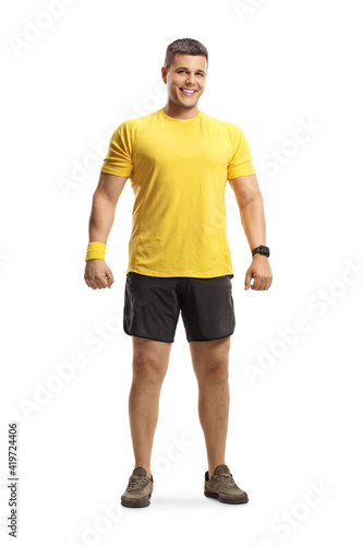 Full length portrait of a young man in sportswear smiling at camera