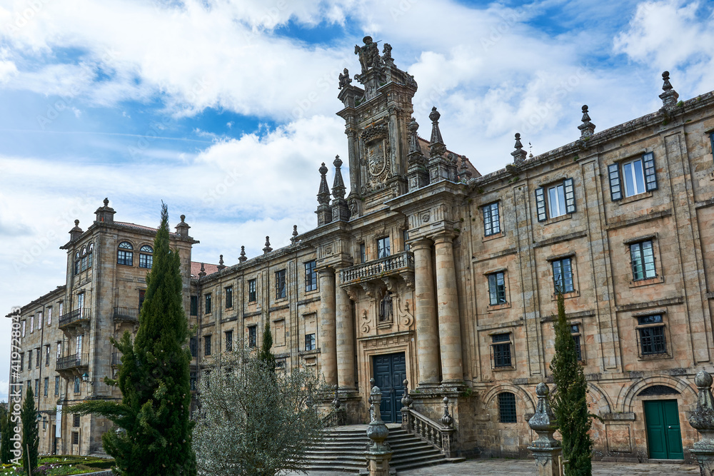 A view of the facade of the Monastery of San Martin Pinario or San Martiño Pinario at historical center of Santiago de Compostela, Galicia, Spain, under blue cloudy sky.