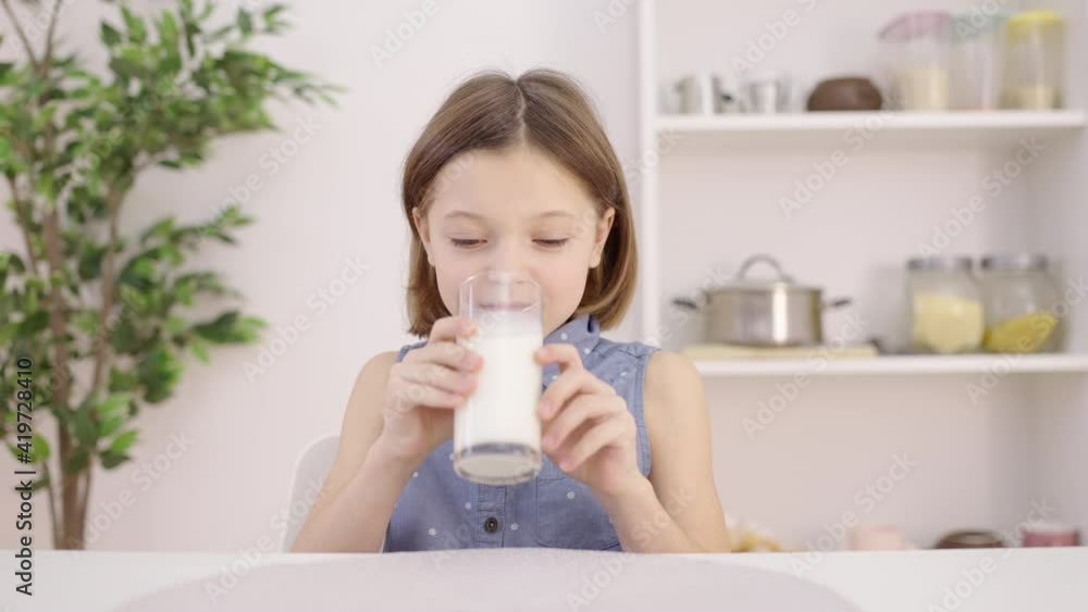 Little girl drinking milk from glass, expired dairy products, bad flavor Little girl drinking milk from glass, expired dairy products, bad flavor