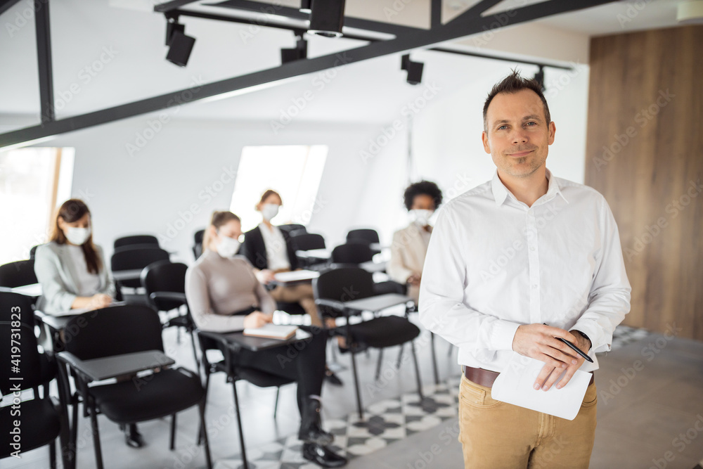 Holding one document, looking at camera.
