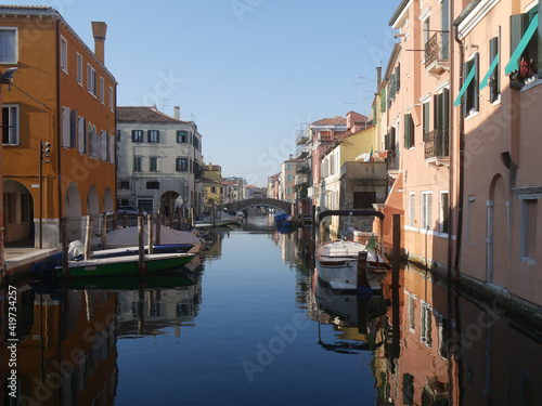 Chioggia, Vena Canal with colorful buildings and crossed by bridges reflected in the water © filippoph