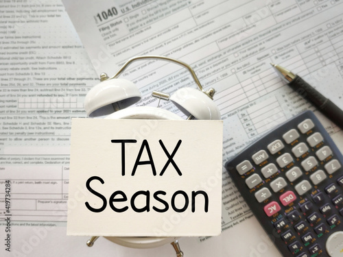 Tax-filling concept - Tax season text on white surface. Top view vintage background. Stock photo.
