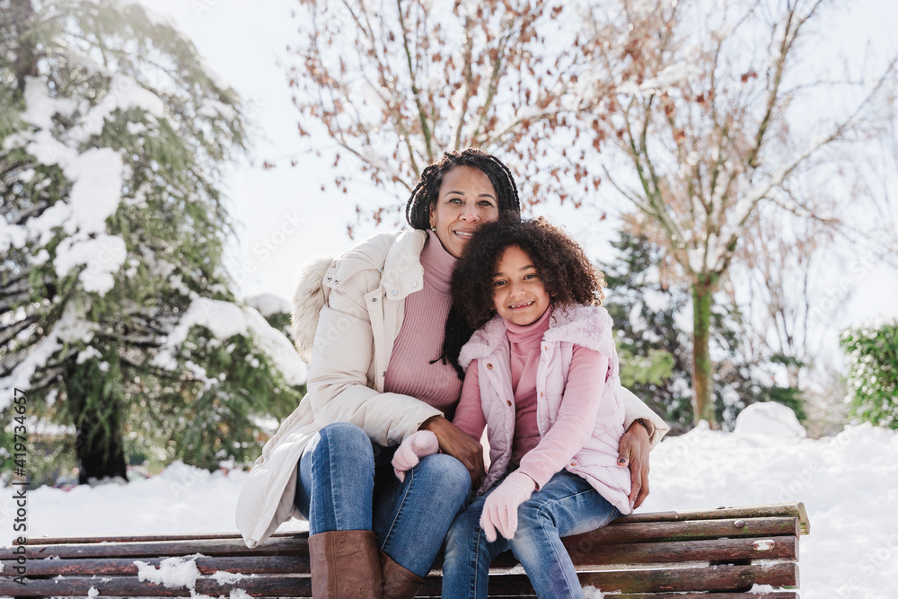 Mother and daughter sitting on bench in park Mother and daughter sitting on bench in park