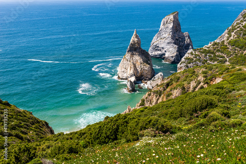 Green coast and stack rocks in sea photo