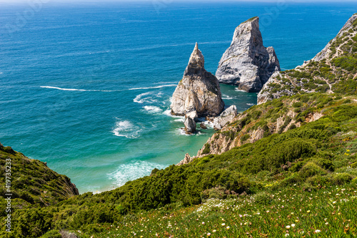 Green coast and stack rocks in sea