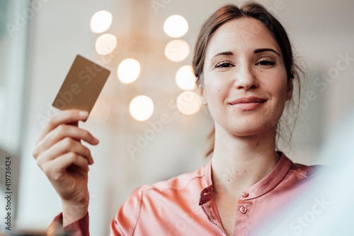 Female customer while paying through credit card at cafe photo