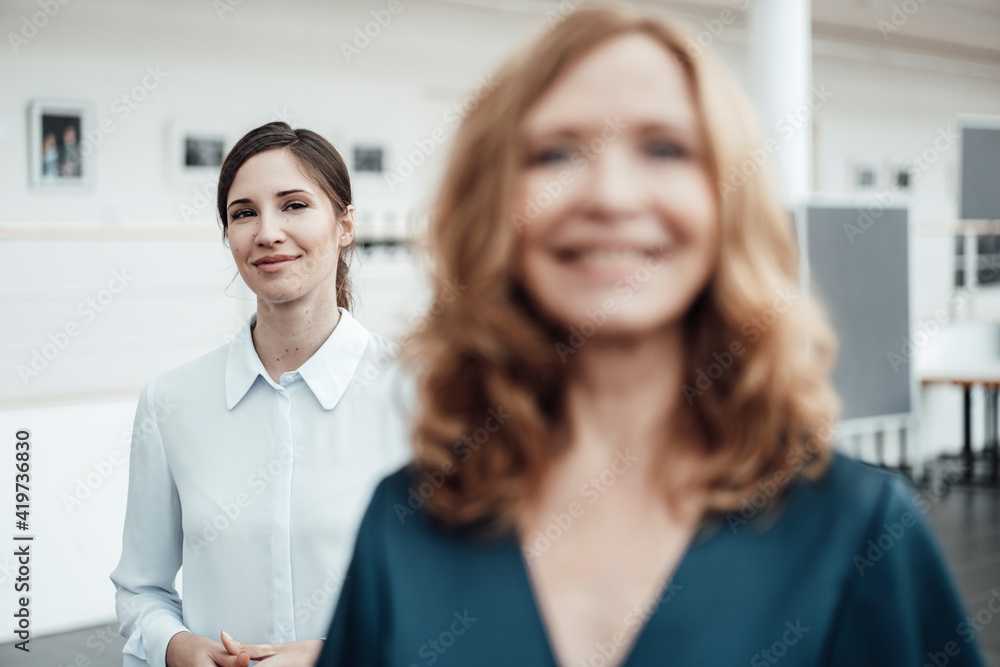 Confident businesswoman with female colleague in office Confident businesswoman with female colleague in office
