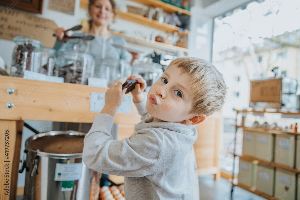 Little boy puckering while having chocolate in candy store Little boy puckering while having chocolate in candy store