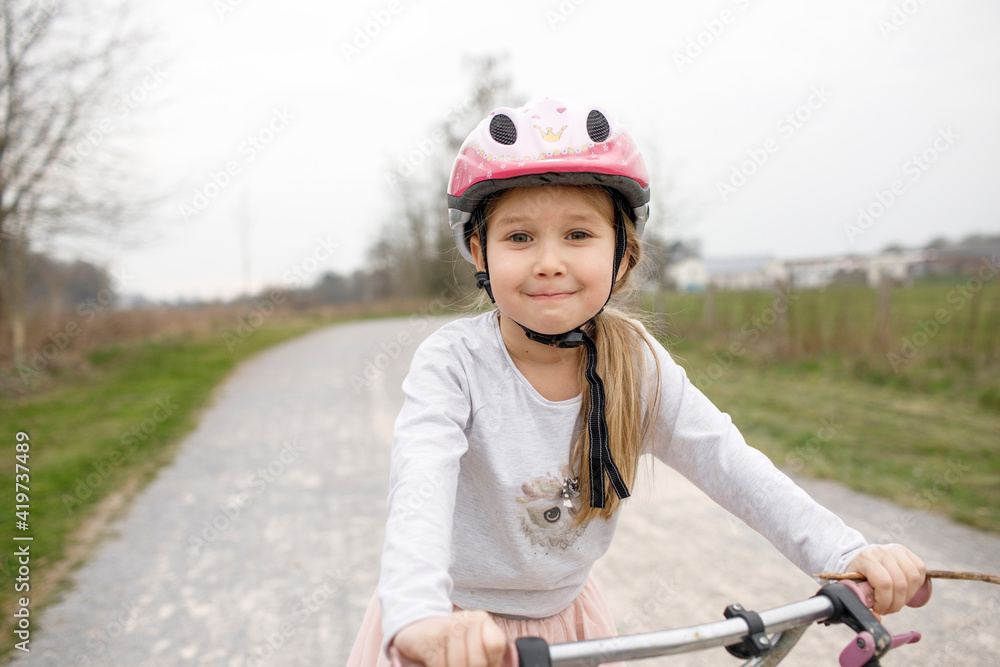 Smiling girl on bicycle wearing cycling helmet Smiling girl on bicycle wearing cycling helmet