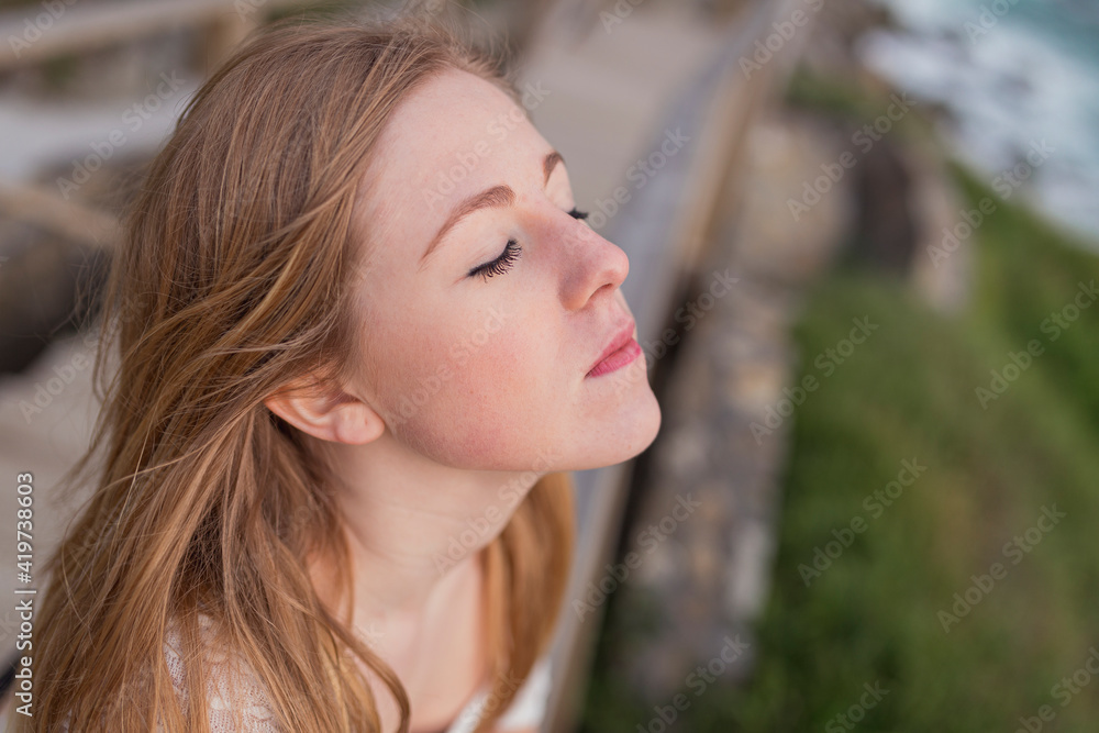 Blond woman with eyes closed at observation point Blond woman with eyes closed at observation point