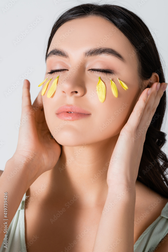 young woman with yellow petals on face isolated on white young woman with yellow petals on face isolated on white