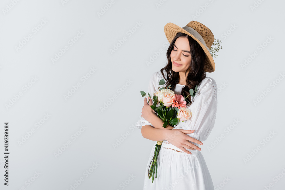 smiling woman in straw hat and dress holding bouquet of spring flowers ...