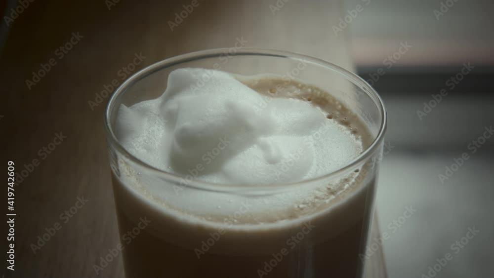 Close-up shot of serving coffee in the glass. Fresh brewed latte with milk foam in the coffee shop Close-up shot of serving coffee in the glass. Fresh brewed latte with milk foam in the coffee shop