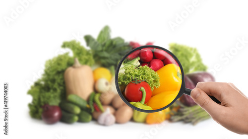 Konstfotografi Woman with magnifying glass exploring vegetables, closeup