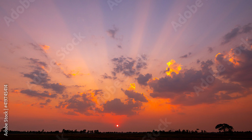 Natural sunset sunrise over field or meadow.Bright dramatic sky and dark ground.Countryside Landscape Under scenic colorful sky at sunset dawn sunrise,Thailand,ASIA.