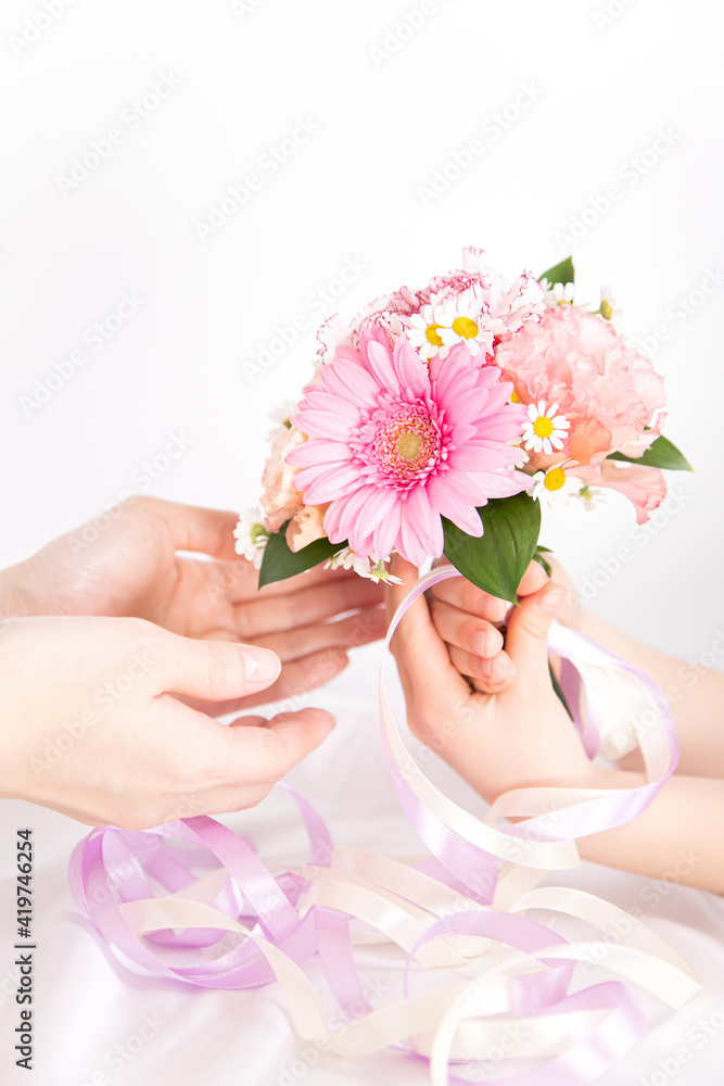 ピンクの花束を渡す子供の手 花のプレゼントイメージ素材 ピンクの花束を渡す子供の手 花のプレゼントイメージ素材