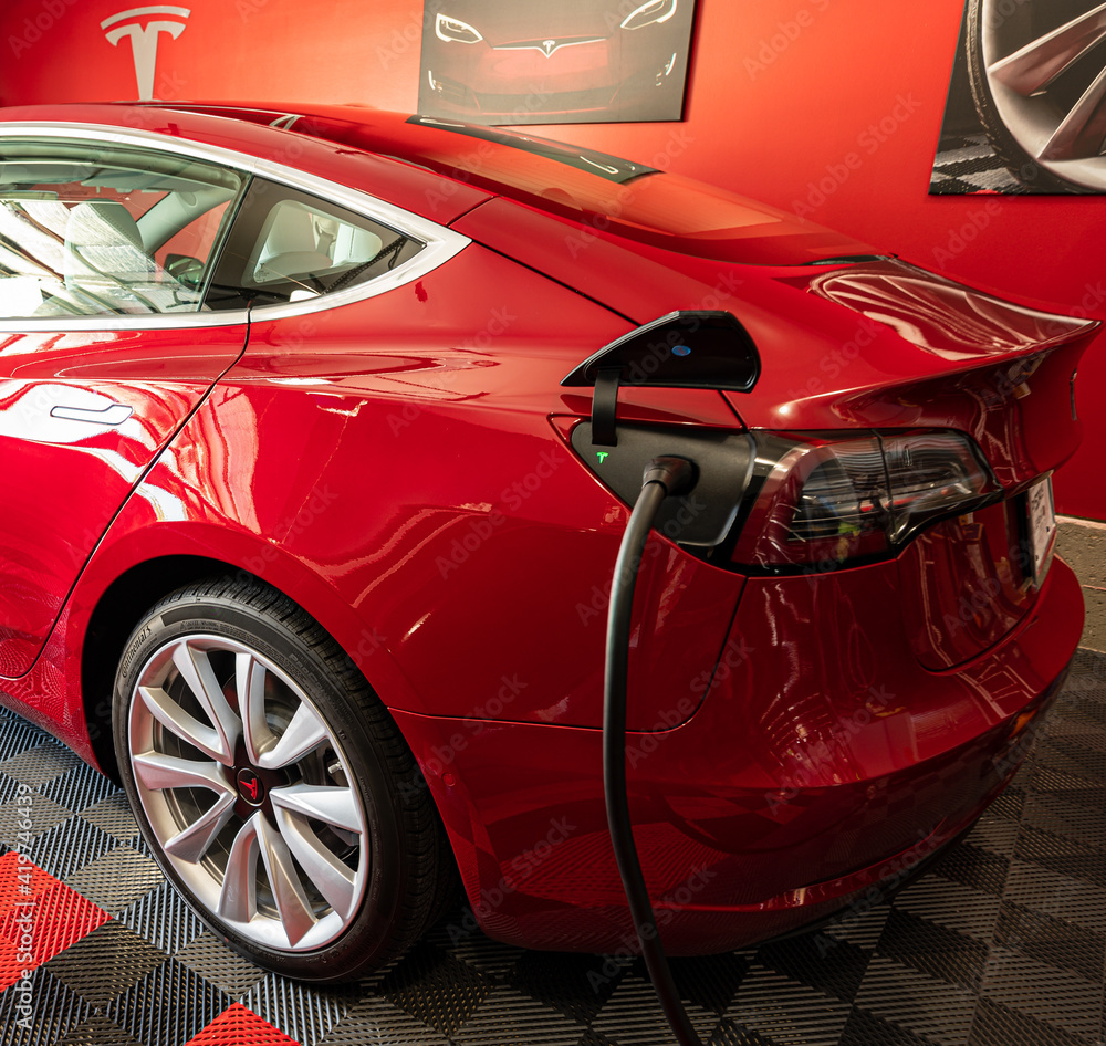Red Tesla Model 3 at Home in the Garage Charging Stock Photo Adobe Stock