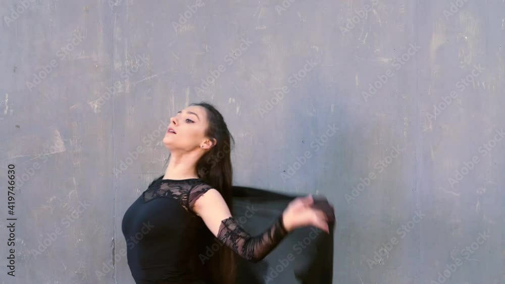 Woman dancer in motion with a cloth against the wall Woman dancer in motion with a cloth against the wall