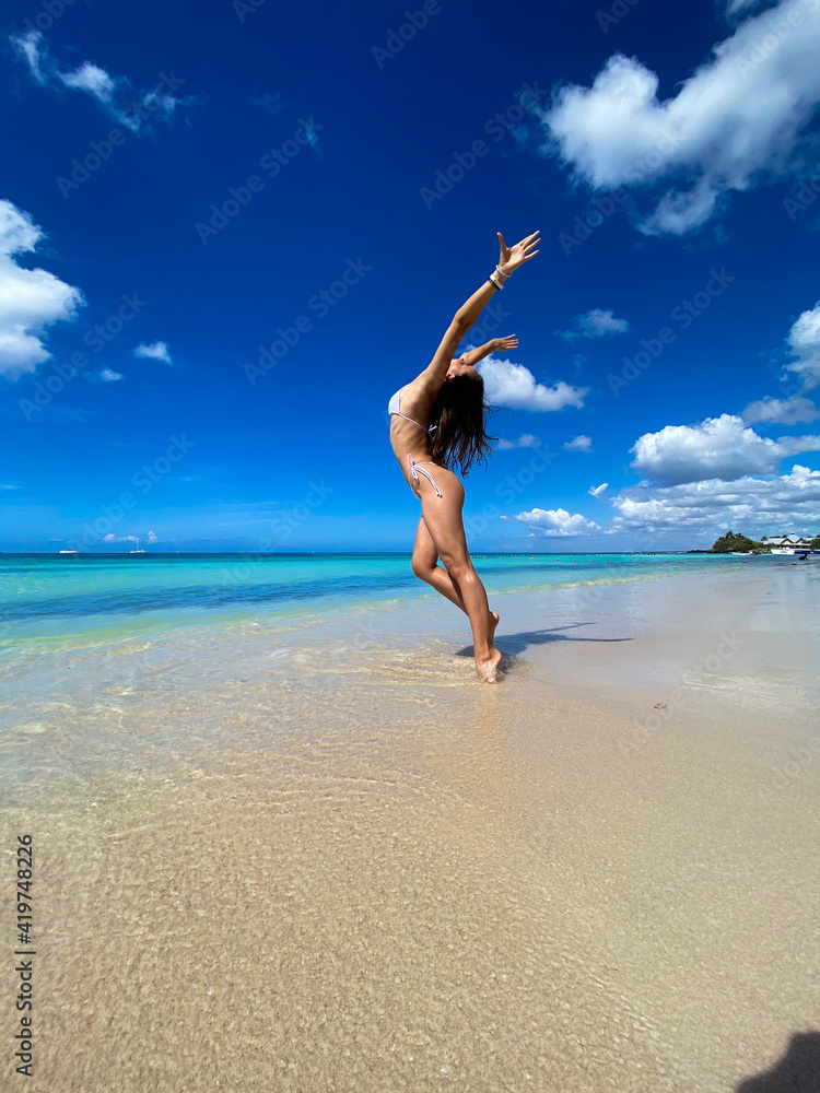 Sexy bikini body woman on paradise tropical beach having fun. Concept of wellness and travel Sexy bikini body woman on paradise tropical beach having fun. Concept of wellness and travel