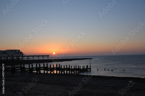 a view of the sun setting behind Aberystwyth pier  © JoeE Jackson