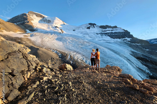 Adventurous couple hiking in mountains with view of  Athabaska glacier.  Mount Athabaska. Columbia Icefields. Alberta. Canada  photo