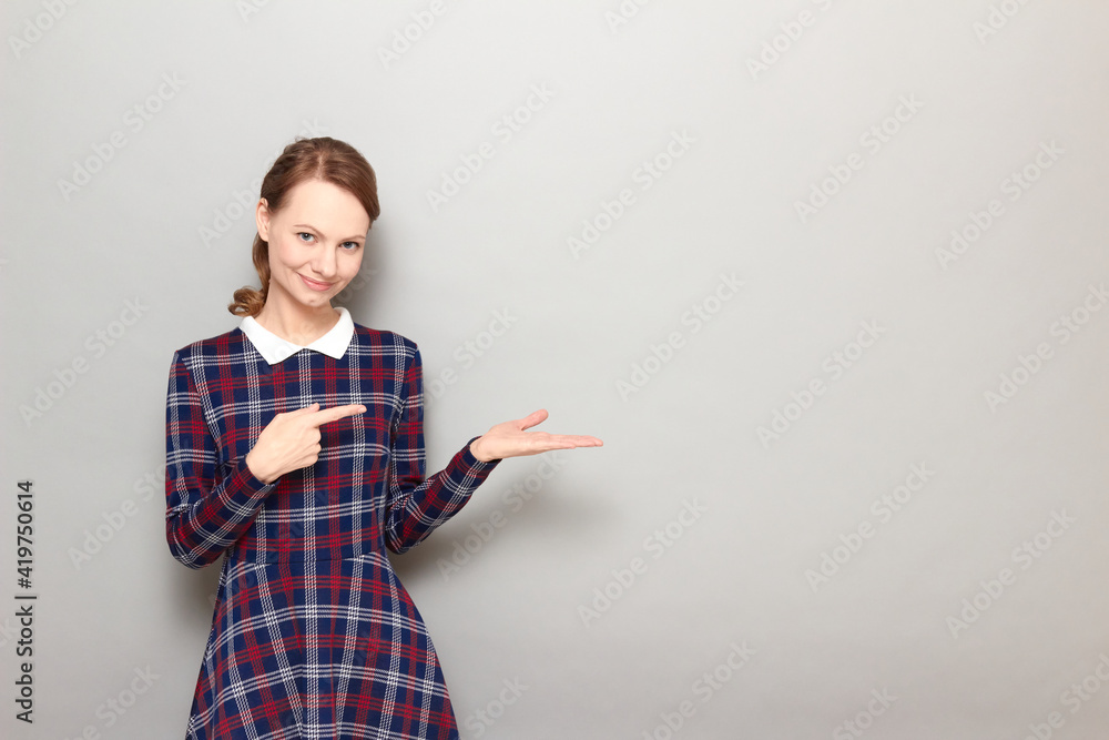 Happy girl is pointing with index finger at copy space on open palm Happy girl is pointing with index finger at copy space on open palm
