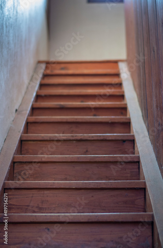 Old wooden stairs . Light coming through the window. Selective focus. Bokeh.