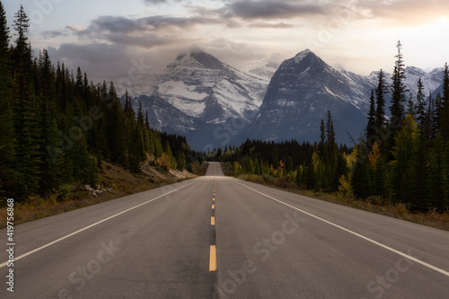 Scenic road in the Canadian Rockies during a vibrant sunny and cloudy summer morning. Artistic Sky Render. Taken in Icefields Parkway, Jasper National Park, Alberta, Canada.