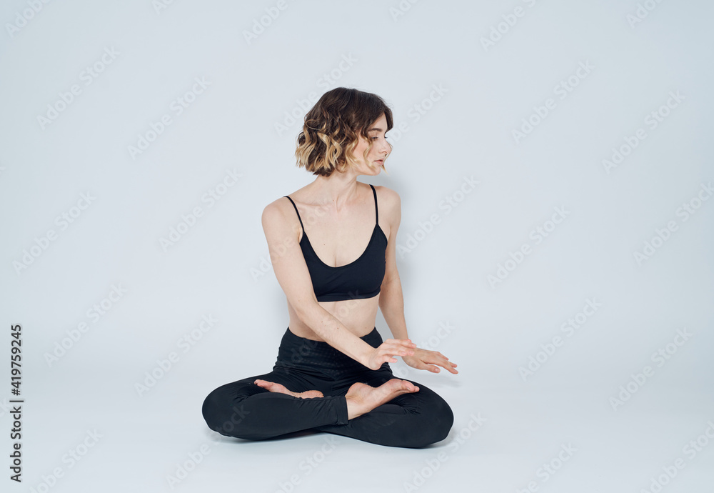 Woman sitting cross-legged on the floor and gesturing with her hands meditation yoga asana