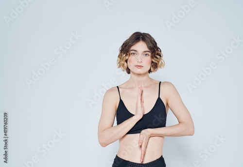 Slender woman in sportswear gestures with her hands yoga meditation