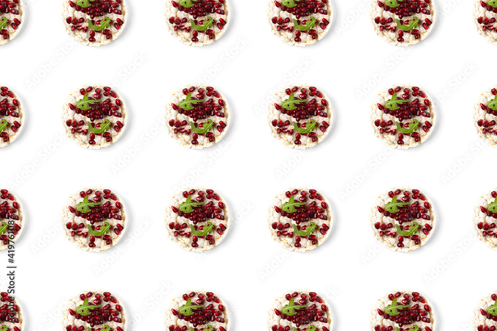 Fototapeta premium Abstract background from galett. Healthy breakfast with rice cake and pomegranate on black flat lay. Pop art