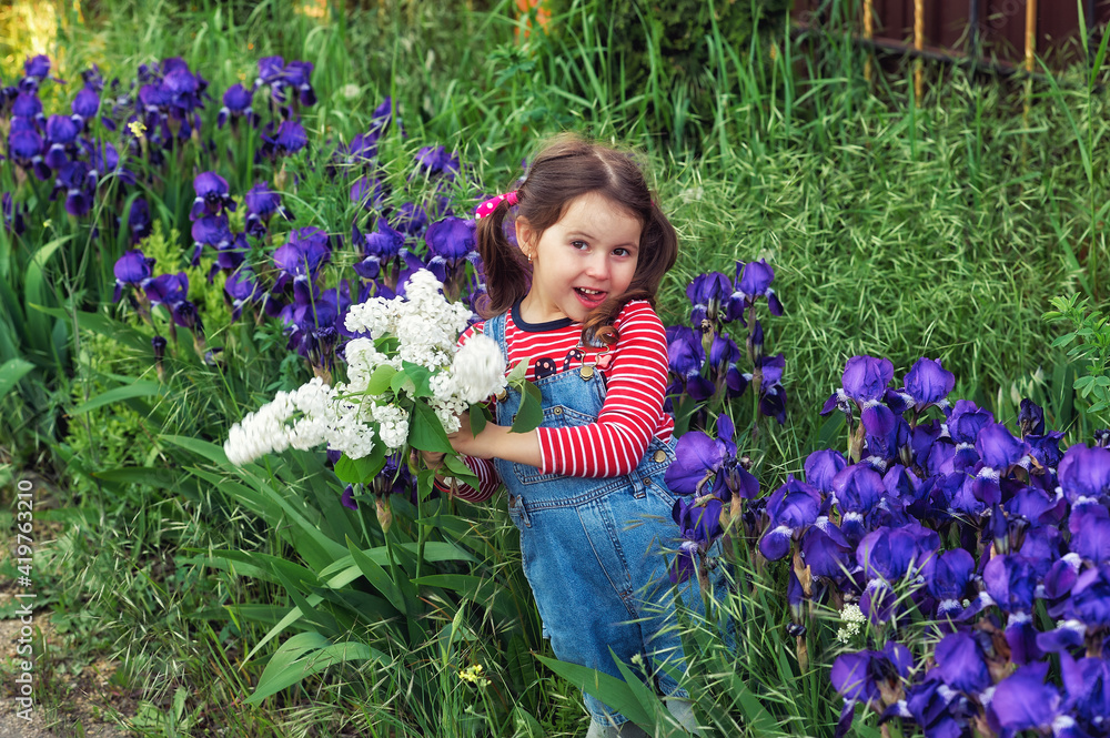 A happy little girl holds a blooming white lilac in her hands A happy little girl holds a blooming white lilac in her hands