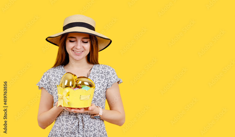 Attractive young cheerful woman with toothy perfect smile holding Easter eggs. Smiling blonde girl looks at the camera and shows. Side blank space for advertising. Space for an inscription. Postcard. Attractive young cheerful woman with toothy perfect smile holding Easter eggs. Smiling blonde girl looks at the camera and shows. Side blank space for advertising. Space for an inscription. Postcard.