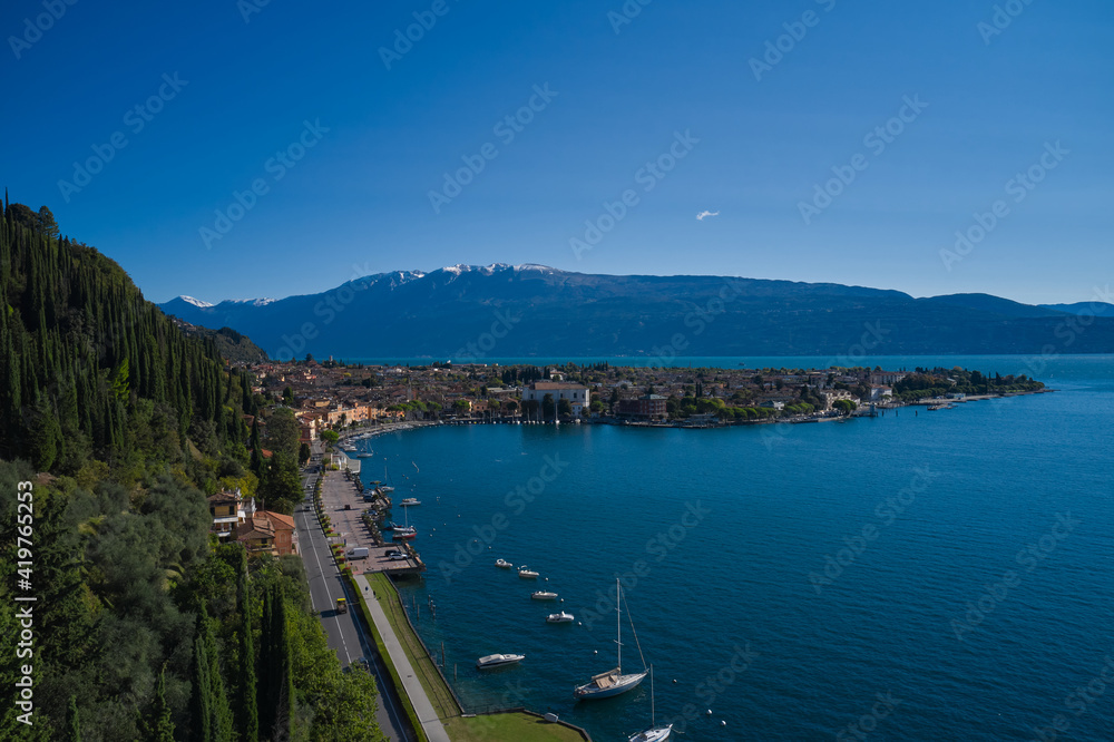 Tourist place on Lake Garda in the background Alps and blue sky. Panoramic view of the historic city of Toscolano Maderno on Lake Garda Italy. Aerial view of the town on Lake Garda.
