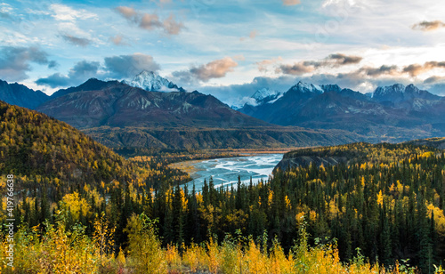 dramatic autumn sunrise in the snow capped Chugach mountain range and Matanuska river in Alaska.